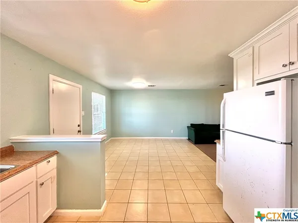 a kitchen with a sink a refrigerator and window