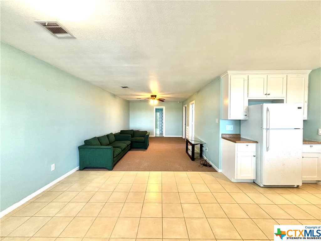 512 West Adams Street Port O'Connor, TX 77982 - Photo 9 of 27 a bedroom with a bed and a refrigerator