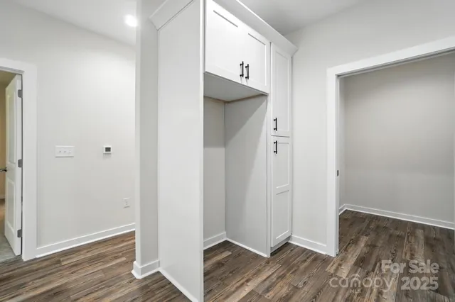 a kitchen with stainless steel appliances granite countertop a stove top oven a sink dishwasher and white cabinets with wooden floor