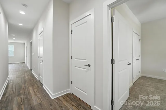 a view of a hallway with wooden floor and closet area