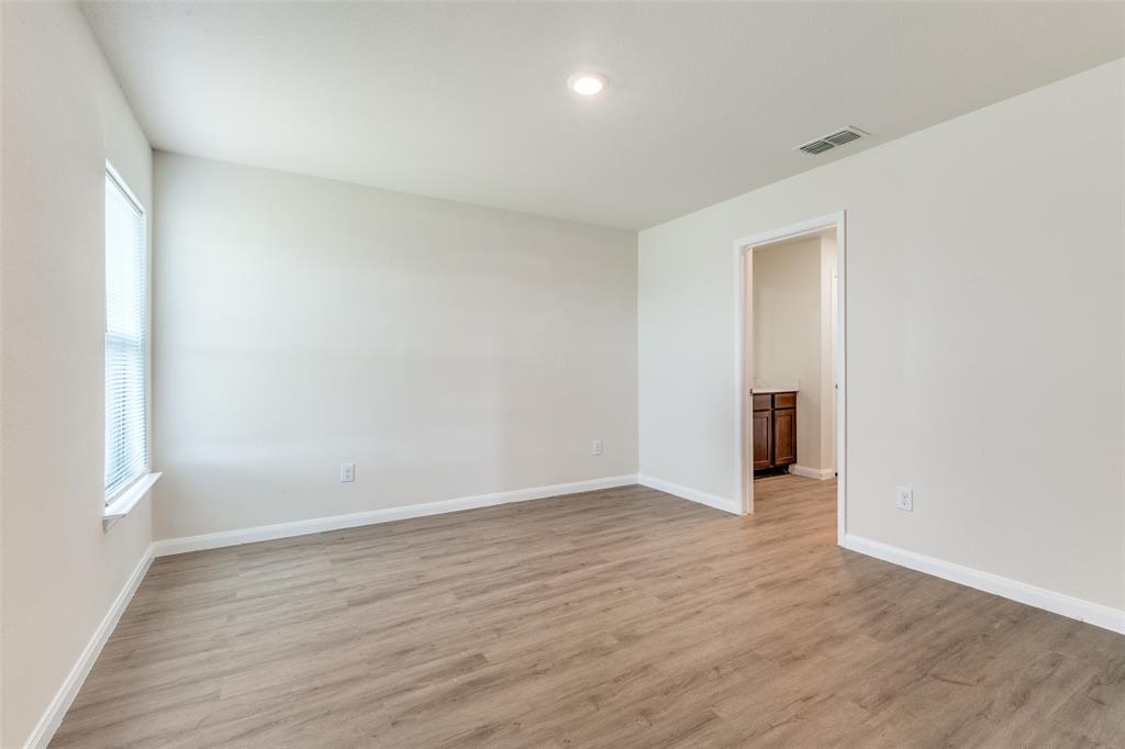 144 Barbwire Way Newark, TX 76071 - Photo 11 of 24 a view of an empty room with wooden floor and a window