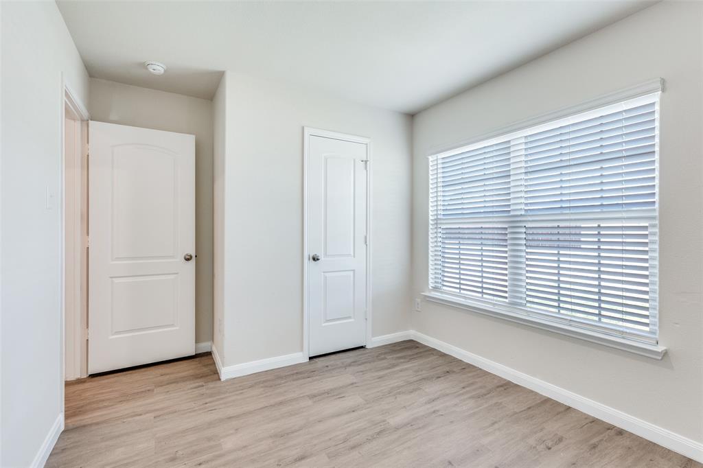 144 Barbwire Way Newark, TX 76071 - Photo 14 of 24 an empty room with wooden floor and windows