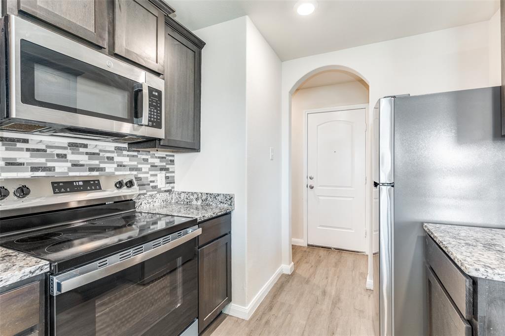 144 Barbwire Way Newark, TX 76071 - Photo 4 of 24 a kitchen with a stove and a microwave