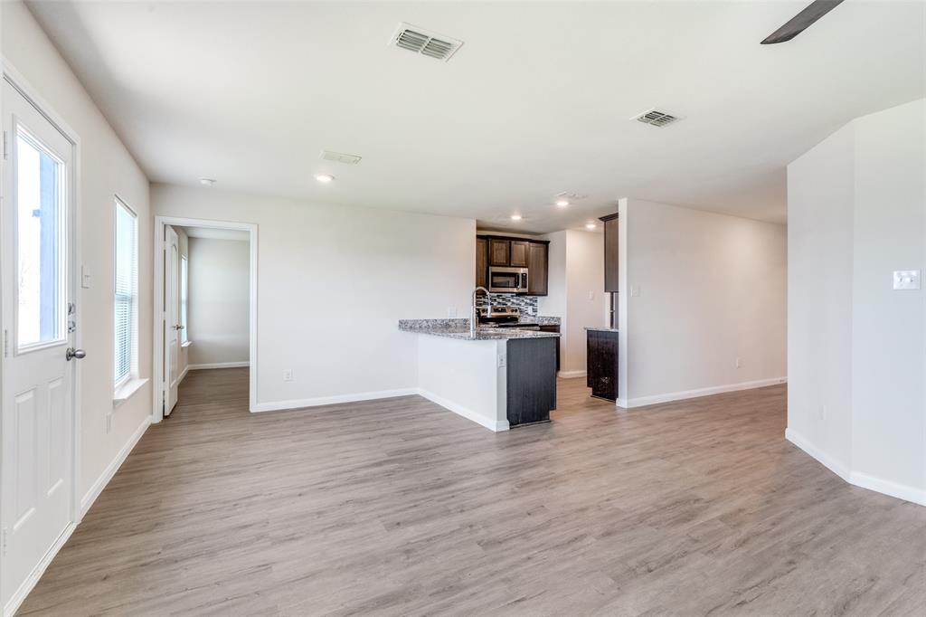 144 Barbwire Way Newark, TX 76071 - Photo 6 of 24 a view of kitchen with stainless steel appliances kitchen island wooden floors and view living room