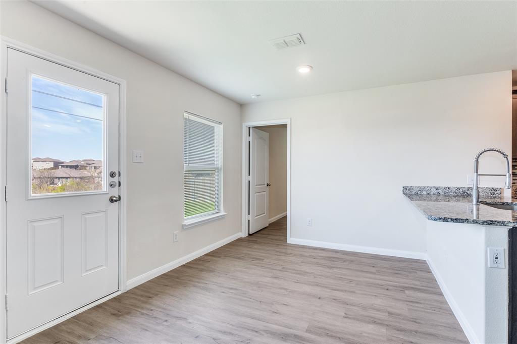 144 Barbwire Way Newark, TX 76071 - Photo 9 of 24 a view of a livingroom with wooden floor and a bathroom