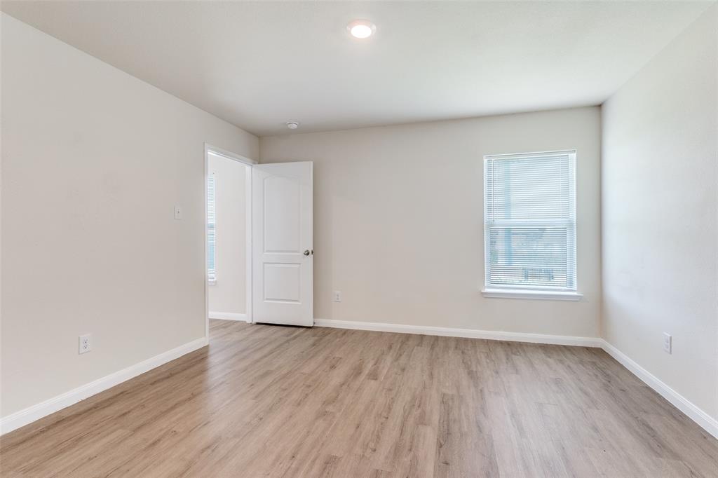 144 Barbwire Way Newark, TX 76071 - Photo 10 of 24 a view of an empty room with wooden floor and a window