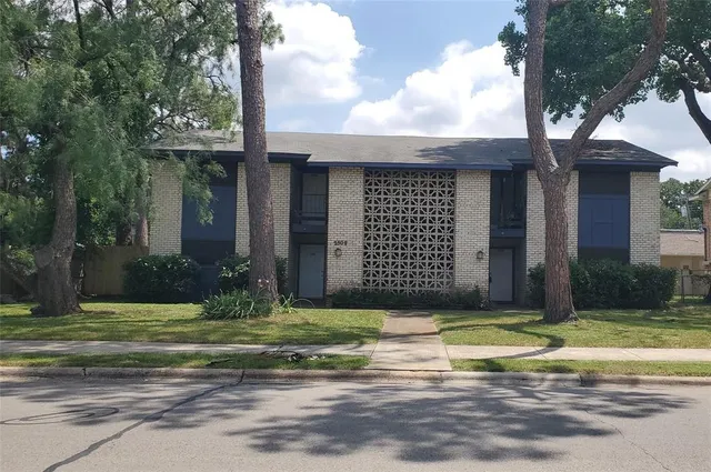 a view of a brick house with a yard