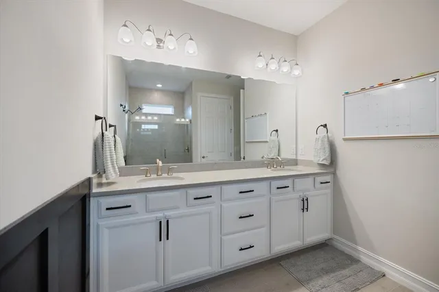 a bathroom with a granite countertop sink double and mirror