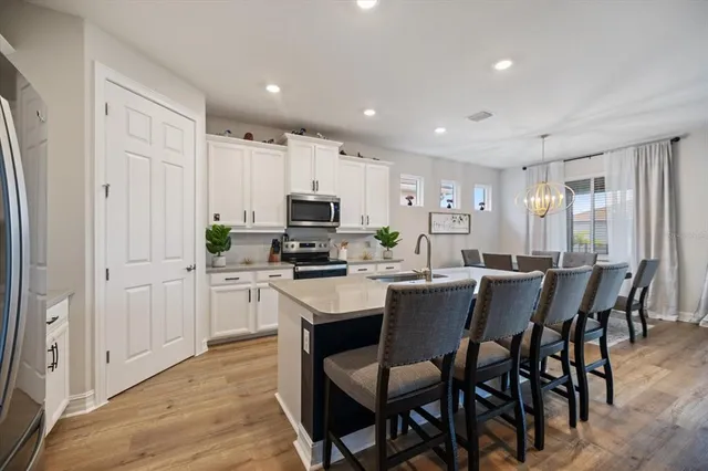 a kitchen with kitchen island white cabinets and stainless steel appliances