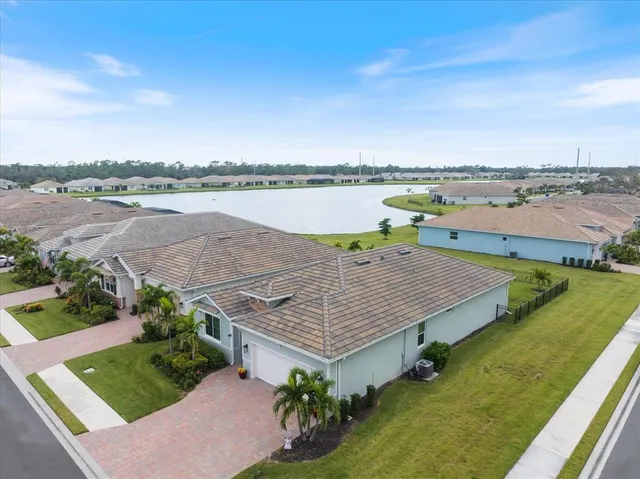 an aerial view of a house with a garden and lake view