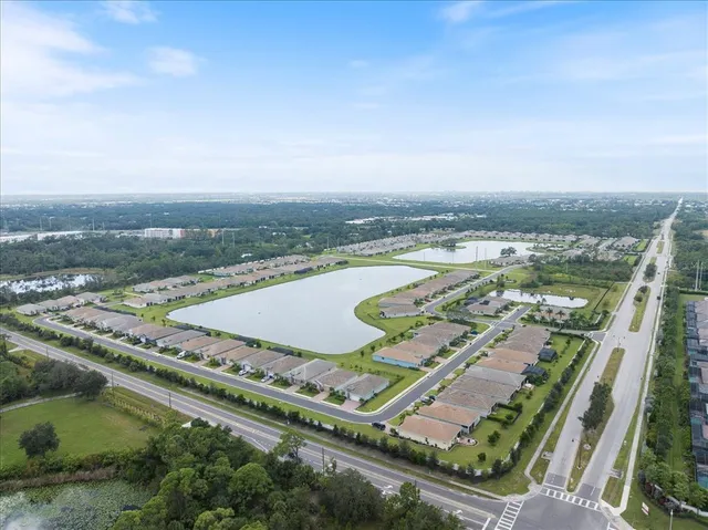 an aerial view of a residential houses with outdoor space and ocean view