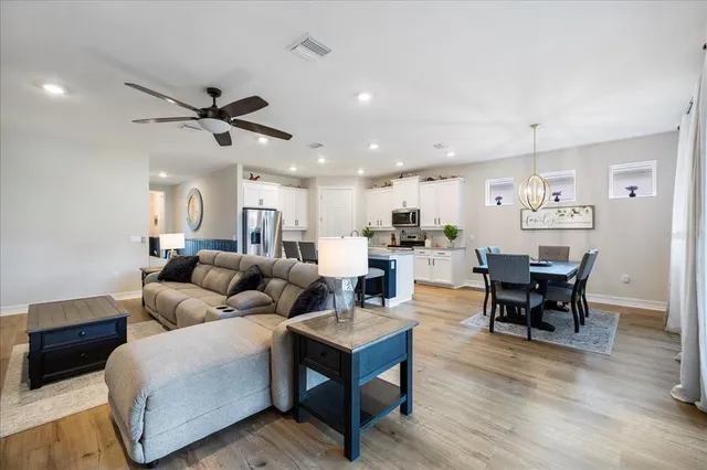 a living room with furniture kitchen view and a dining table