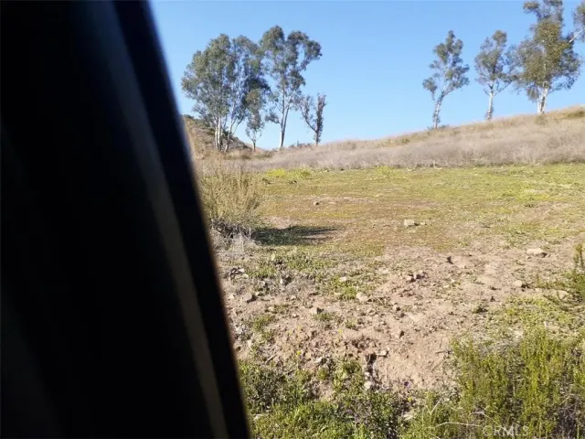 a view of a dry yard with wooden fence