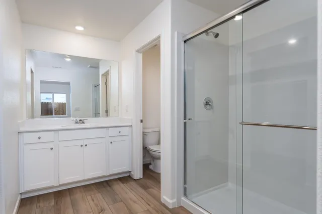 a spacious bathroom with a granite countertop sink mirror and shower