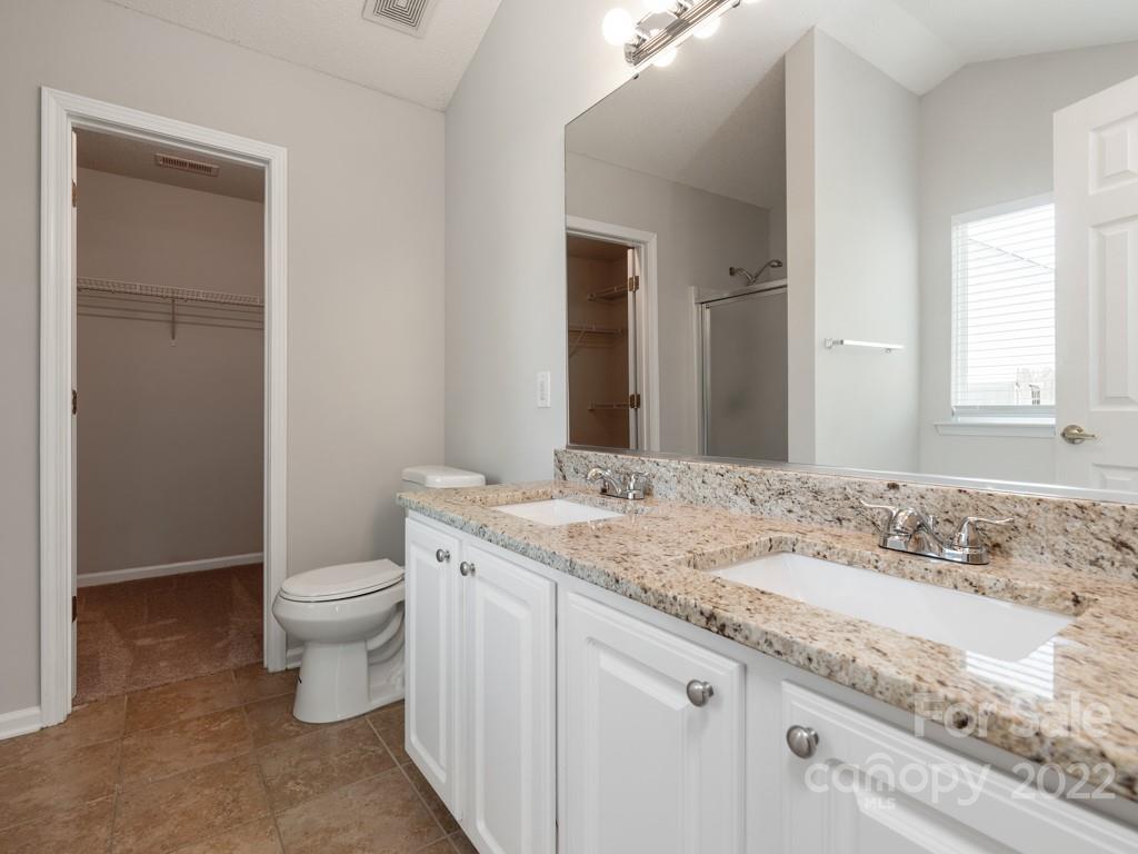 8215 Fox Swamp Road Charlotte, NC 28215 - Photo 12 of 25 a bathroom with a granite countertop toilet sink and mirror