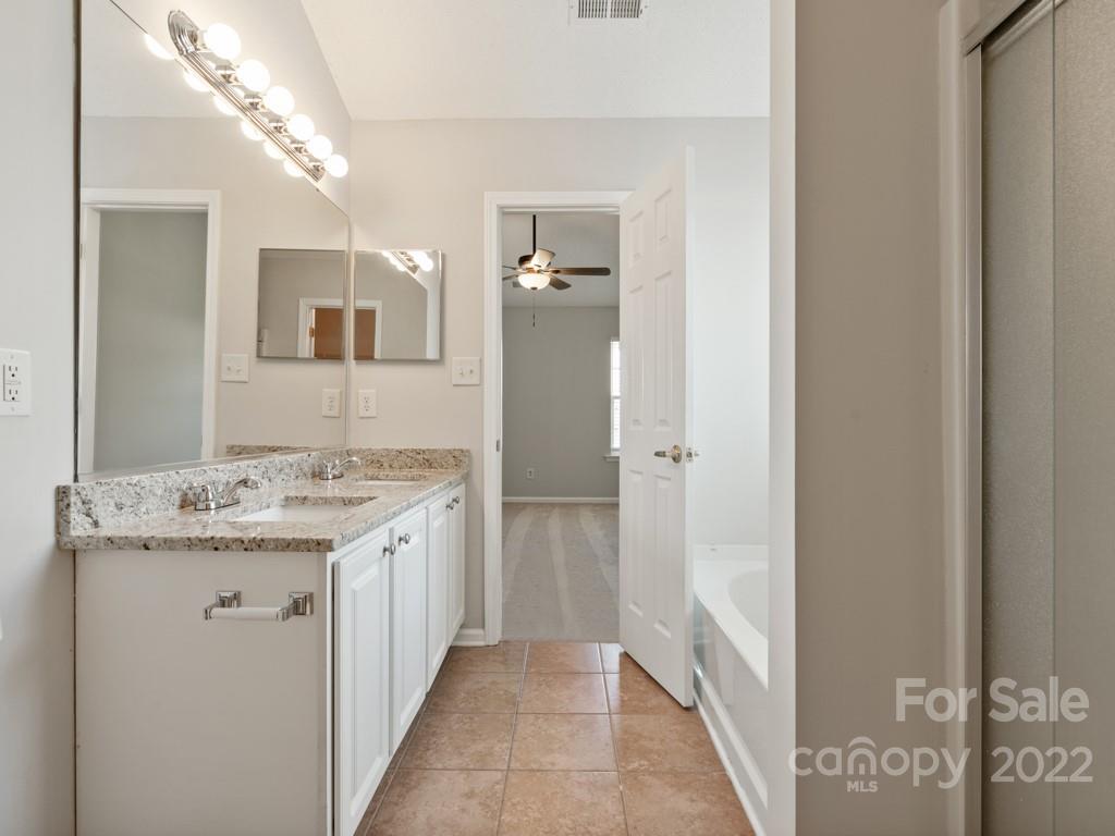 8215 Fox Swamp Road Charlotte, NC 28215 - Photo 13 of 25 a bathroom with a granite countertop sink a mirror and a shower