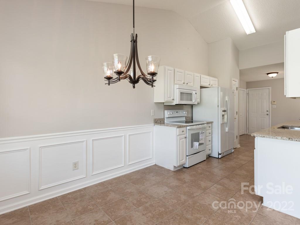 8215 Fox Swamp Road Charlotte, NC 28215 - Photo 6 of 25 a kitchen with white cabinets and white appliances