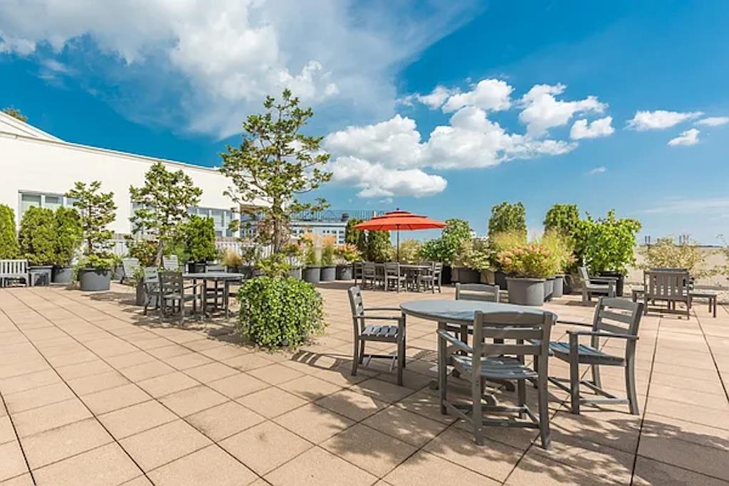 27-28 Thomson Avenue, Unit 804 Queens, NY 11101 - Photo 13 of 17 a view of a chairs and table in a patio