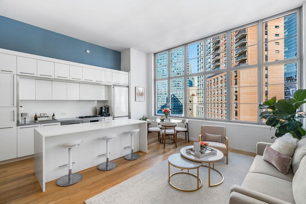 27-28 Thomson Avenue, Unit 804 Queens, NY 11101 - Photo 2 of 17 a living room with furniture and a large window