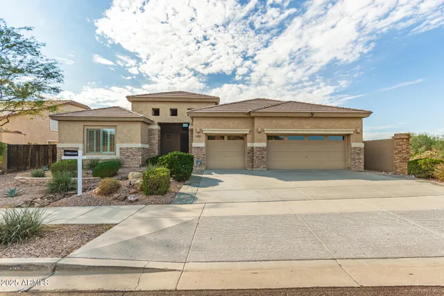 a front view of a house with a yard and potted plants