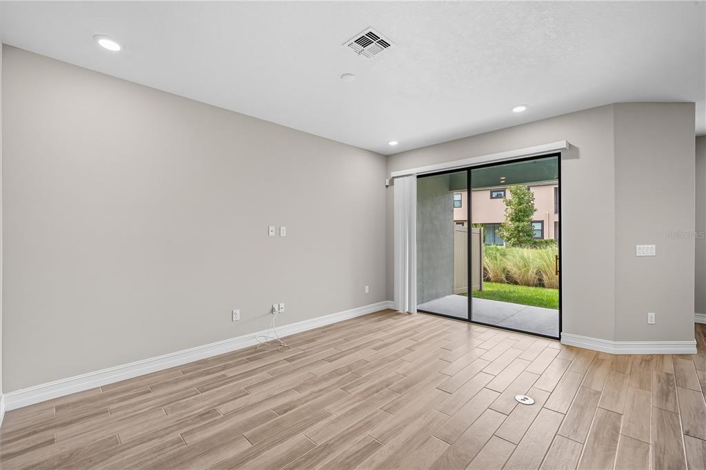 4663 Almada Lane Wesley Chapel, FL 33543 - Photo 11 of 30 an empty room with wooden floor and windows