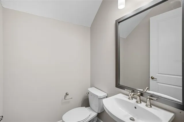 a bathroom with a toilet a sink and mirror