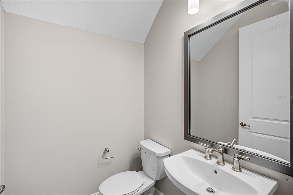 4663 Almada Lane Wesley Chapel, FL 33543 - Photo 6 of 30 a bathroom with a toilet a sink and mirror
