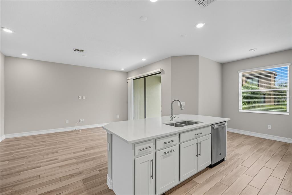 4663 Almada Lane Wesley Chapel, FL 33543 - Photo 8 of 30 a bathroom with a granite countertop sink a mirror and a window