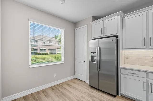 a view of a kitchen with refrigerator and wooden floor