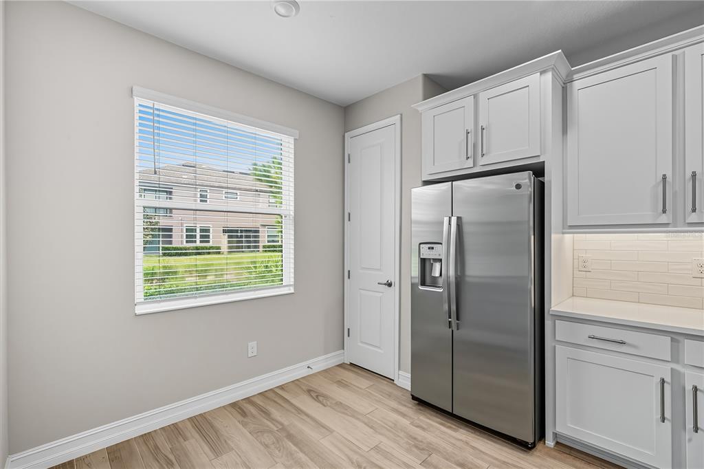 4663 Almada Lane Wesley Chapel, FL 33543 - Photo 9 of 30 a view of a kitchen with refrigerator and wooden floor