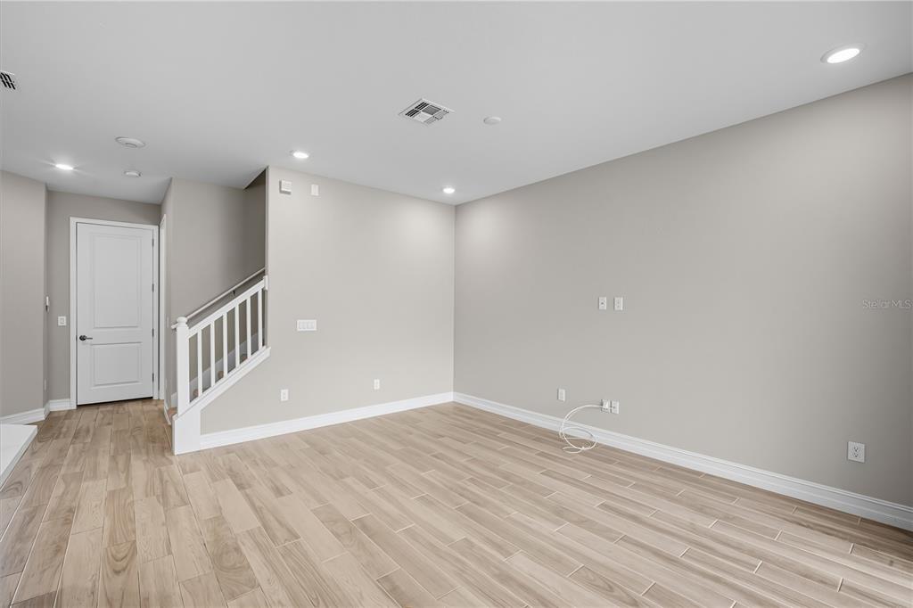 4663 Almada Lane Wesley Chapel, FL 33543 - Photo 10 of 30 a view of an empty room with wooden floor