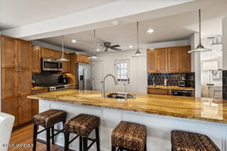 220 13th Avenue Belmar, NJ 07719 - Photo 12 of 21 a kitchen with stainless steel appliances granite countertop a stove top oven a sink a dining table and chairs with wooden floor
