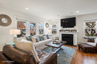 220 13th Avenue Belmar, NJ 07719 - Photo 6 of 21 a living room with furniture a flat screen tv and a fireplace