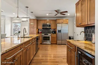 a kitchen with stainless steel appliances granite countertop a sink a stove and a refrigerator