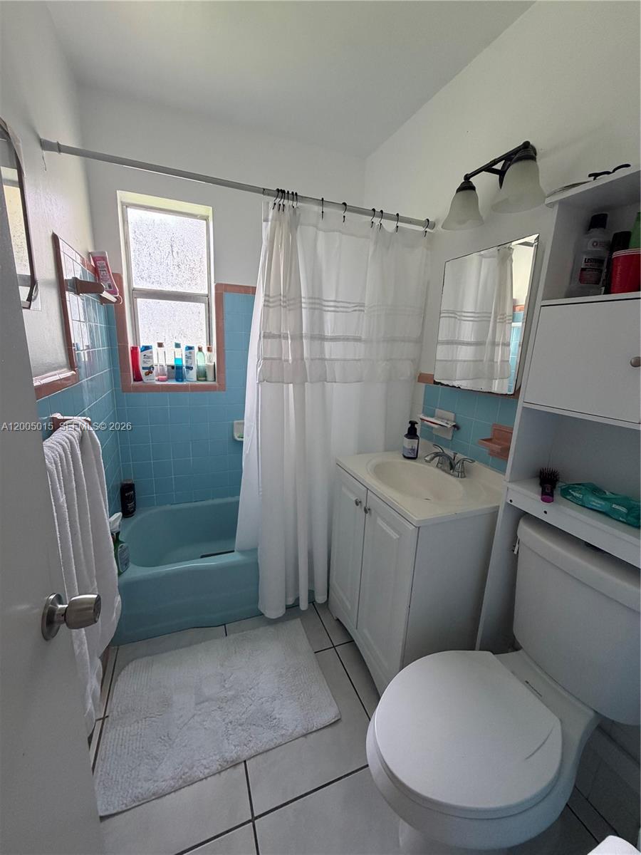 3361 Southwest 28th Street Miami, FL 33133 - Photo 16 of 17 a white toilet sitting next to a bathroom sink and tub