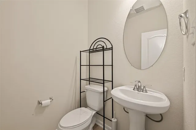 a bathroom with a sink a toilet and a mirror