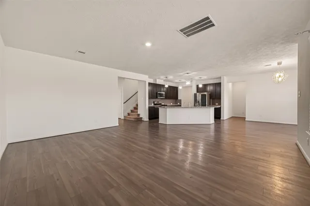 a view of a kitchen with a fridge and wooden floor