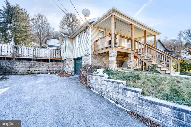 a view of a house with a yard and wooden fence