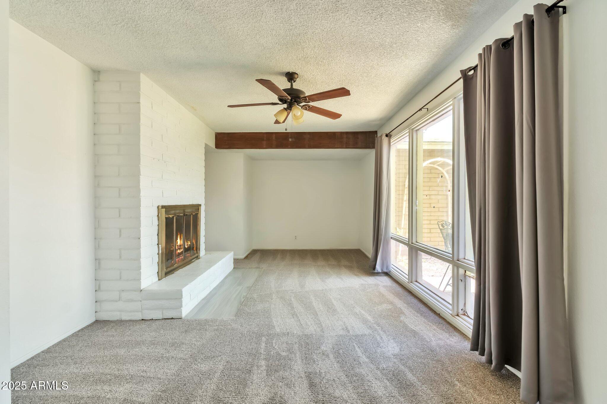 504 North Emerson Mesa, AZ 85201 - Photo 5 of 19 a view of a livingroom with a fireplace a ceiling fan and windows