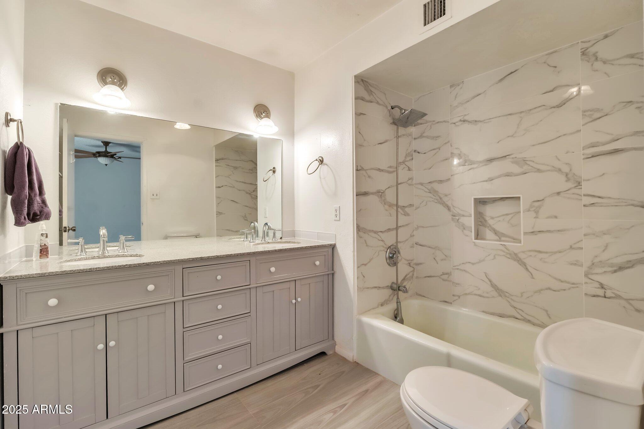 504 North Emerson Mesa, AZ 85201 - Photo 10 of 19 a bathroom with a granite countertop toilet a sink and bathtub