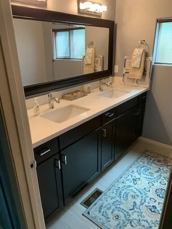 a bathroom with a double vanity sink and a mirror
