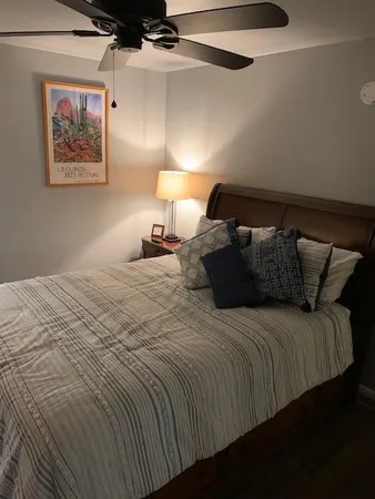 a bedroom with a bed and a painting on the wall