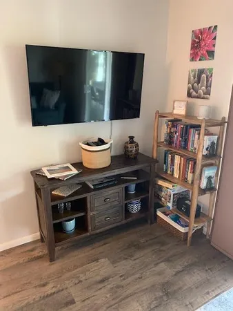 a living room with a flat screen tv and a bookshelf
