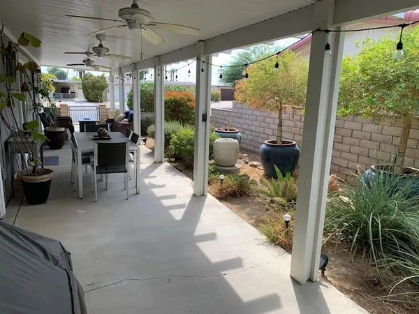 a patio view with a table and chairs and potted plants