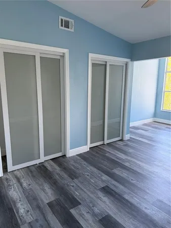 a view of a livingroom with wooden floor & window