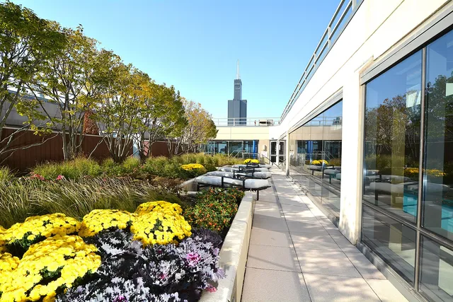 a living room with patio furniture and a dining table with floor to ceiling window