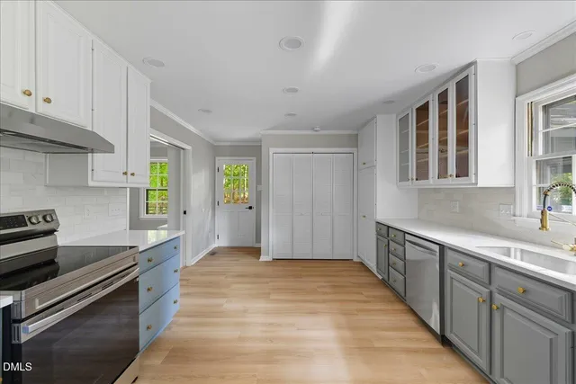 a kitchen with granite countertop a sink stove and cabinets