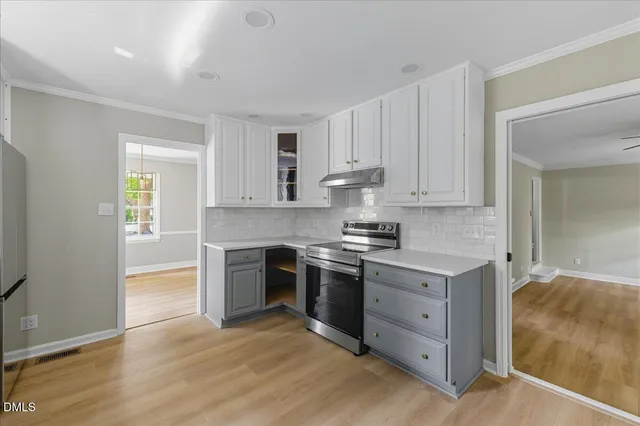 a kitchen with granite countertop white cabinets and stainless steel appliances