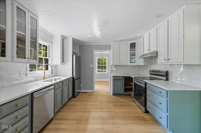 a large kitchen with stainless steel appliances granite countertop a stove sink and cabinets