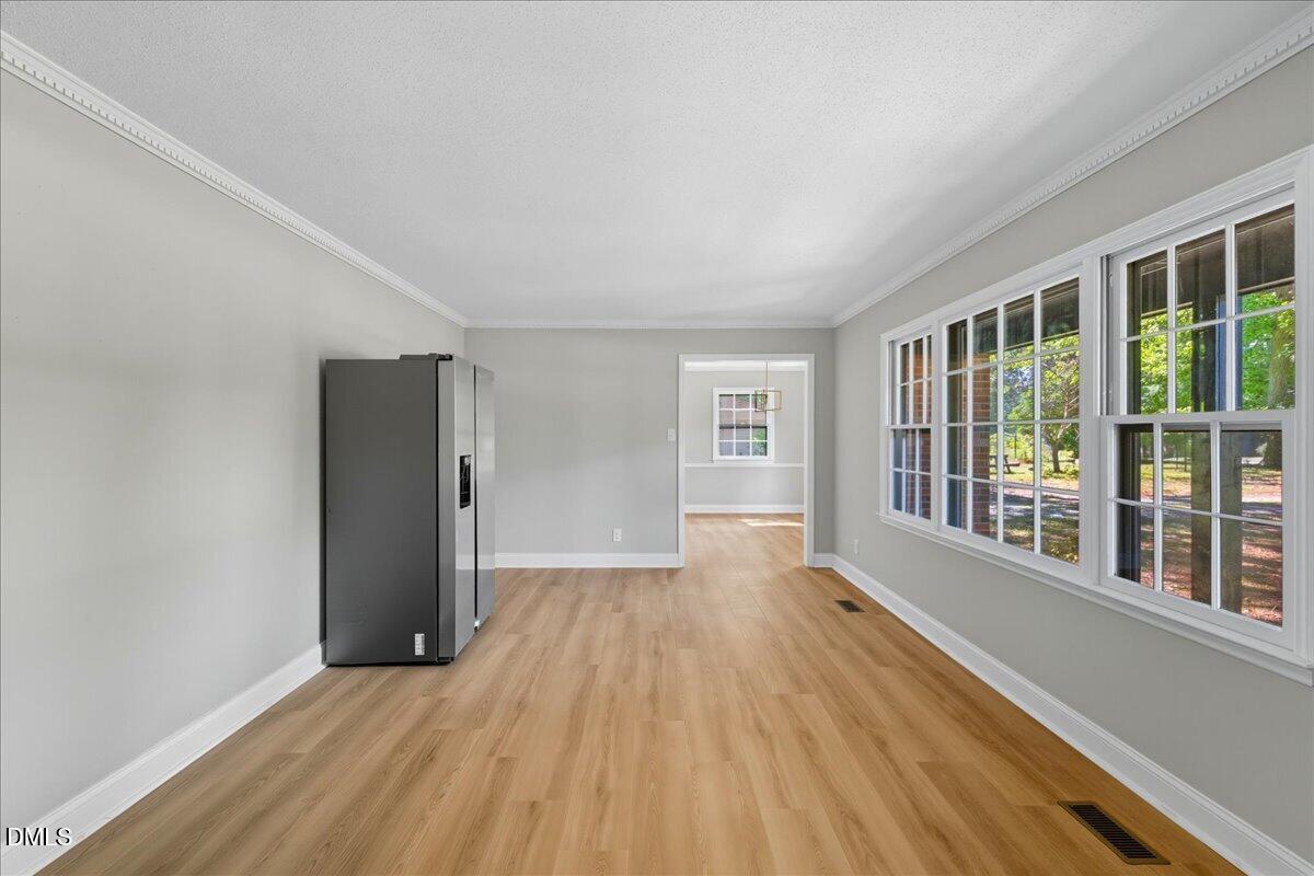 1214 East Oak Drive Durham, NC 27712 - Photo 5 of 36 a view of an empty room with a window and wooden floor